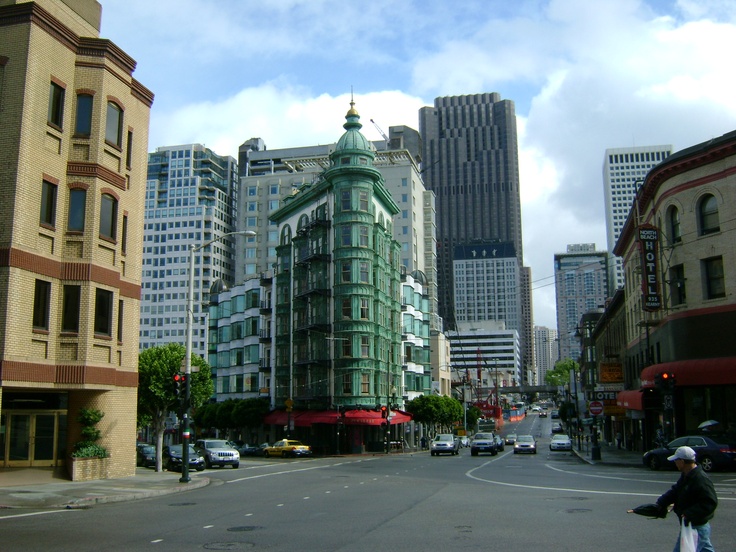 a man riding a bike down a street next to tall buildings in the city center