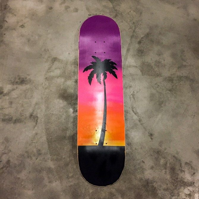 a skateboard with a palm tree painted on it