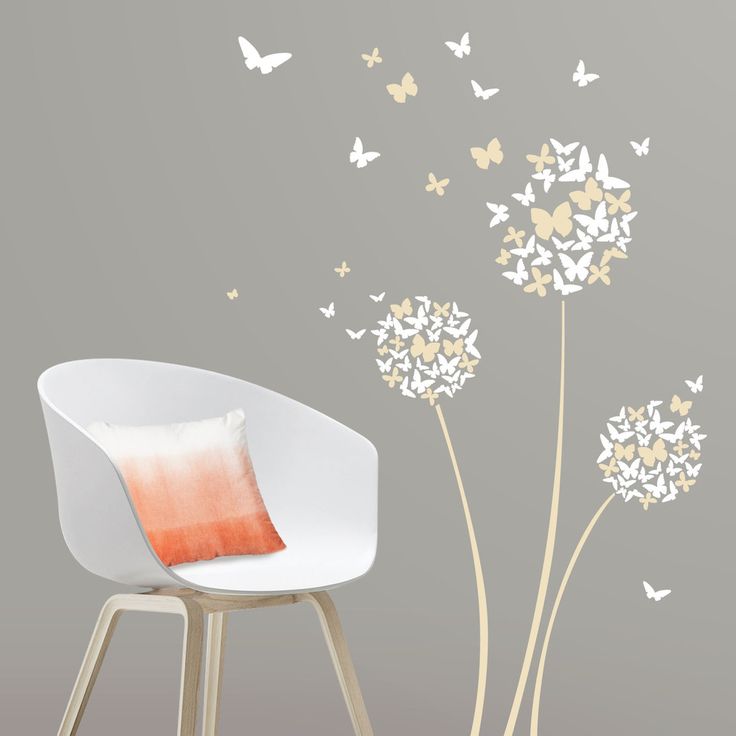 a white chair sitting in front of a wall with dandelions and butterflies on it