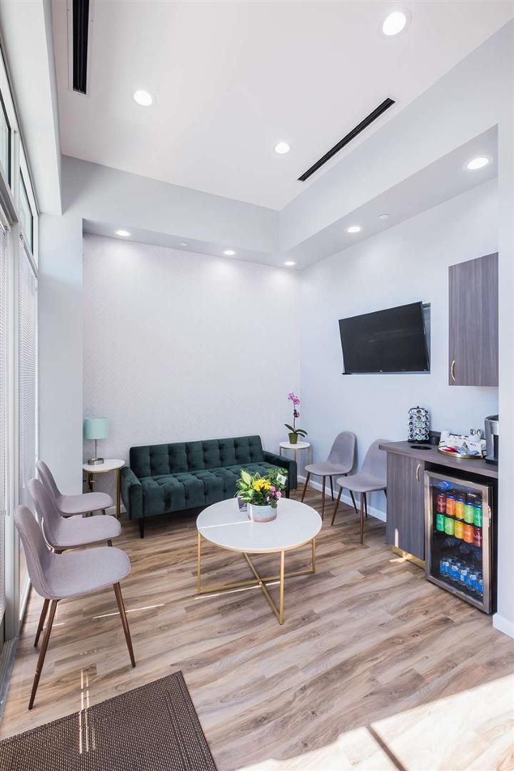 a living room filled with furniture and a flat screen tv mounted on the wall above a fireplace