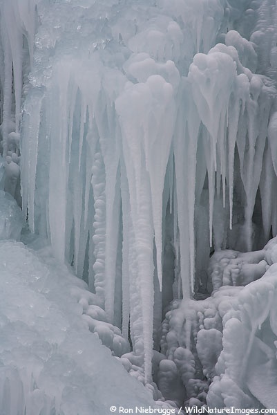 an ice covered waterfall with icicles hanging from it's sides