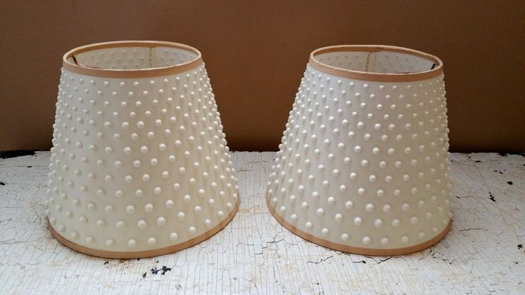 two white lampshades sitting next to each other on top of a countertop