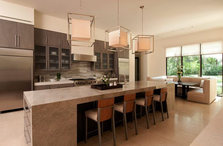 a modern kitchen with stainless steel appliances and marble countertops