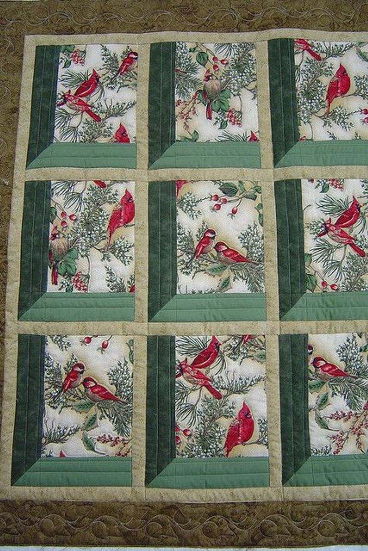 a quilted wall hanging with red birds on green and white squares in the center