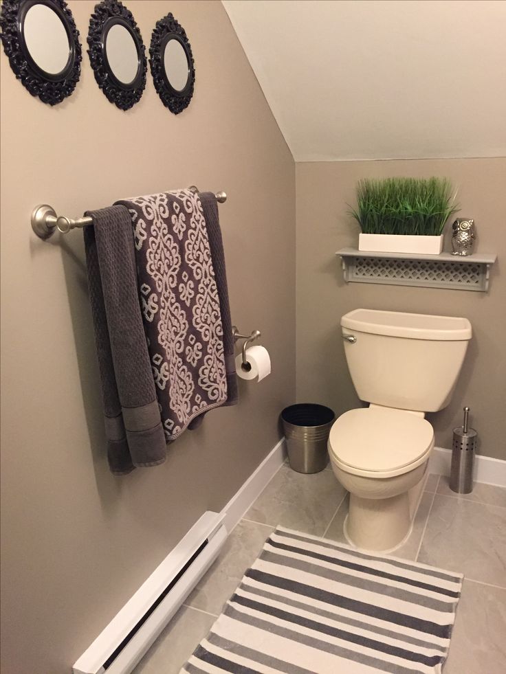 a white toilet sitting in a bathroom next to a towel rack and potted plant