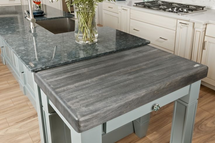 a kitchen with an island in the middle and white cabinets on both sides, along with stainless steel appliances