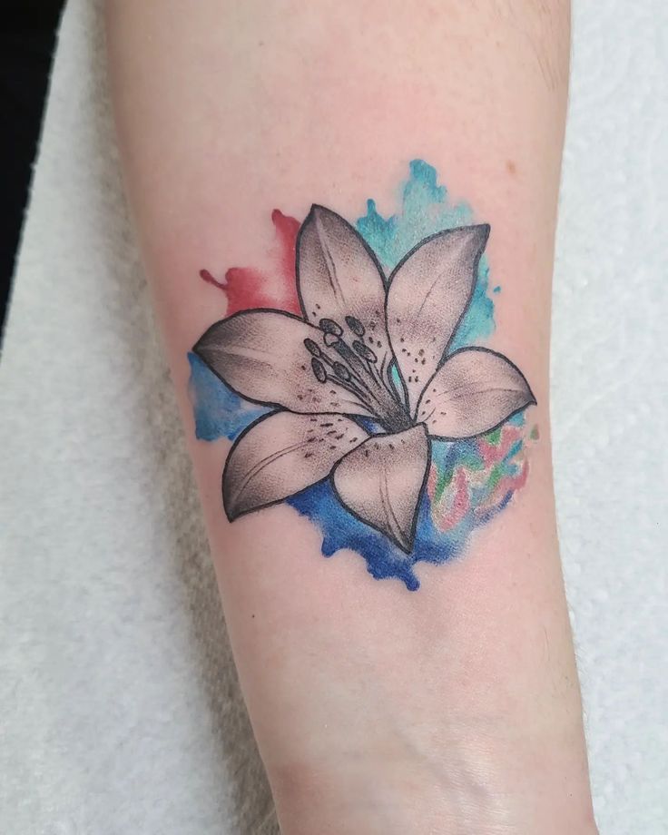 a watercolor style flower tattoo on the arm