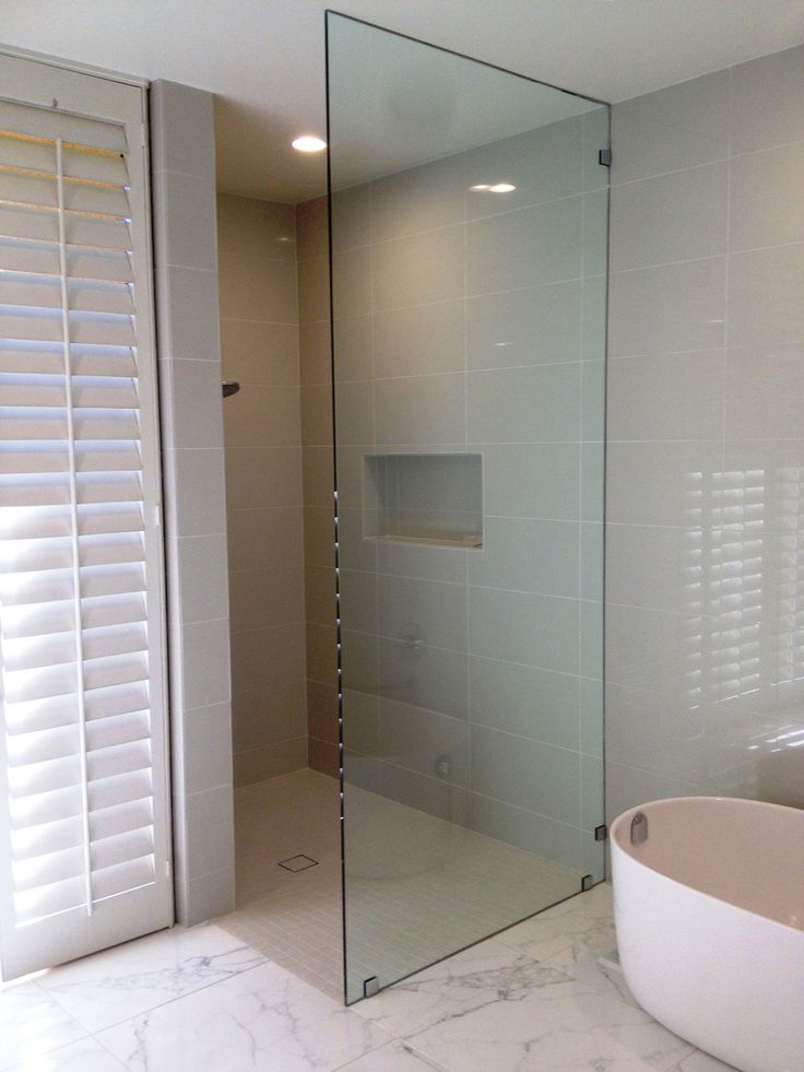 a bath room with a tub and a mirror on the wall next to a window