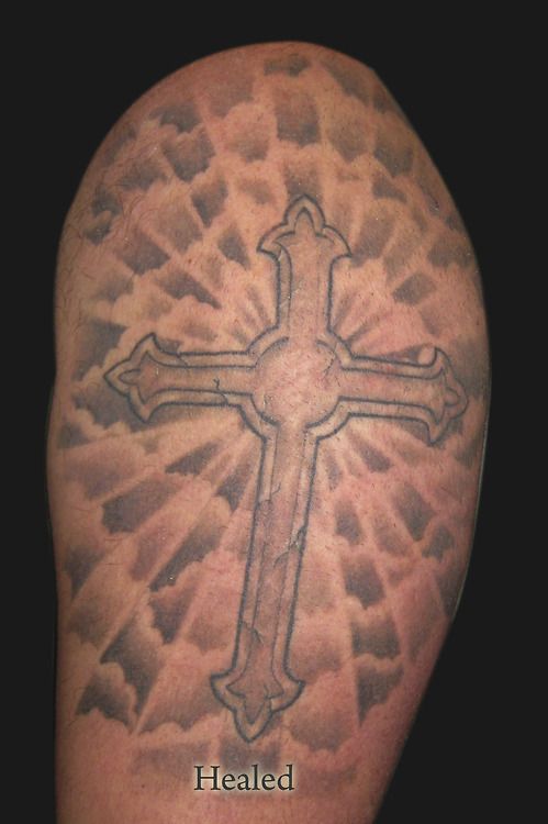 a man with a cross tattoo on his arm that says, healed and the word below it