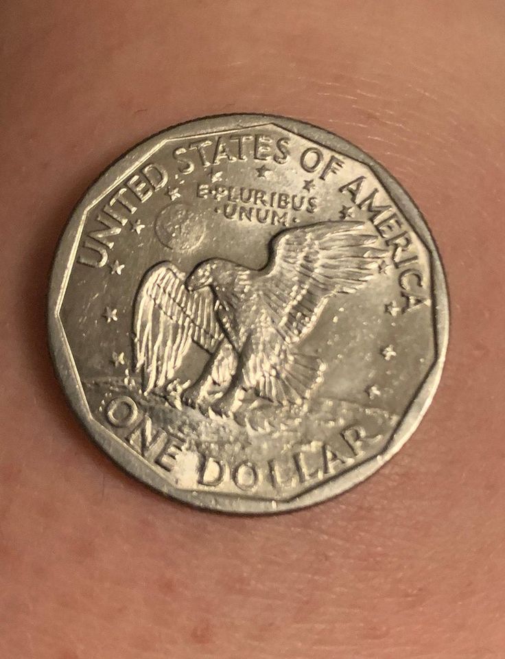 a close up of a person's arm with a coin in the foreground