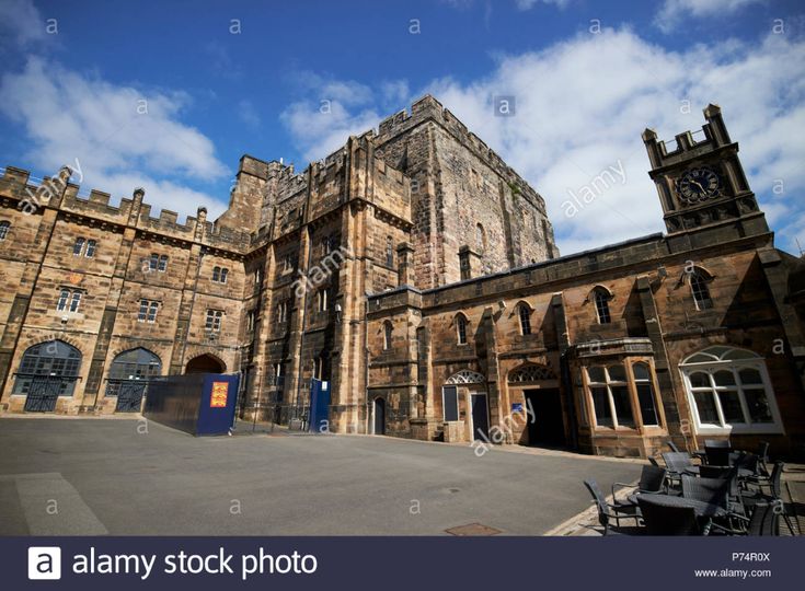 an old stone building with a clock tower on the front and blue sky in the background