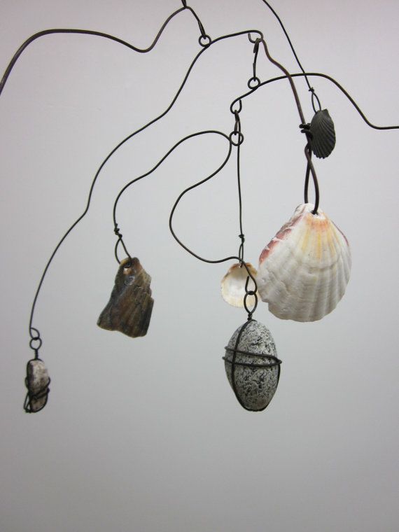 three seashells are hanging from a wire