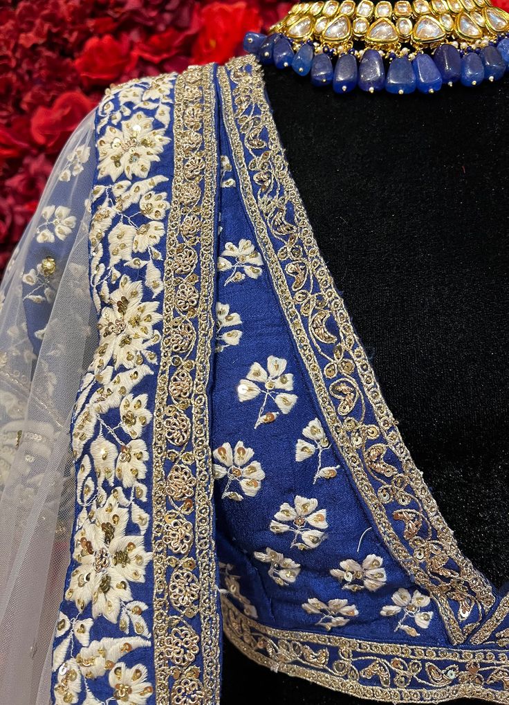 Subtle hues of whimsy blend with floral embroideries in this Royal Blue lehenga. The mehreen lehenga, embroidered with beautiful floral motifs and golden embroidery work, looks every bit of the royal self! Color - Fabric & Work Style -- Silk lehenga: Rich embroidery, floral embroidery work.- Silk embroidered blouse.- Net dupatta. Details -- Assured quality.- Wash care instruction: Dry clean only.- Slight variation in color is possible due to digital photography. Floral Embroidered Choli For Eid Reception, Floral Embroidered Choli For Reception Eid, Designer Raw Silk Sharara With Floral Embroidery, Floor-length Dupatta With Intricate Embroidery For Festive Occasions, Traditional Drape Choli With Floral Embroidery For Reception, Reception Choli With Floral Embroidery And Traditional Drape, Raw Silk Sharara With Floral Embroidery For Reception, Floor-length Lehenga With Floral Embroidery For Festivals, Floral Embroidered Raw Silk Sharara For Receptions