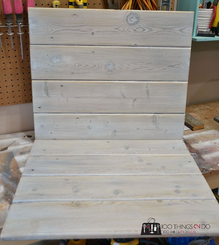 a chair made out of wood sitting on top of a workbench