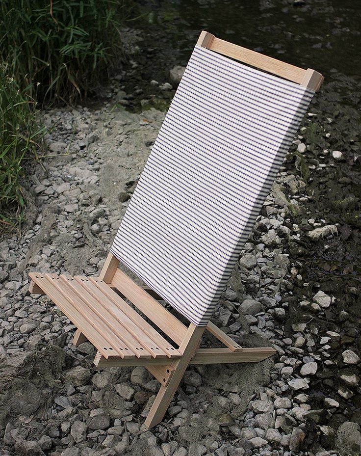 a folding chair sitting on top of a rocky beach