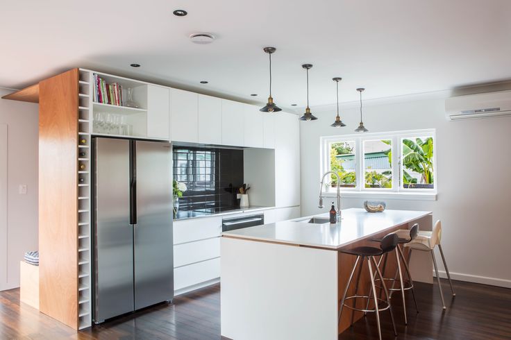 a modern kitchen with stainless steel appliances and white cabinets, wood floors, and hardwood flooring