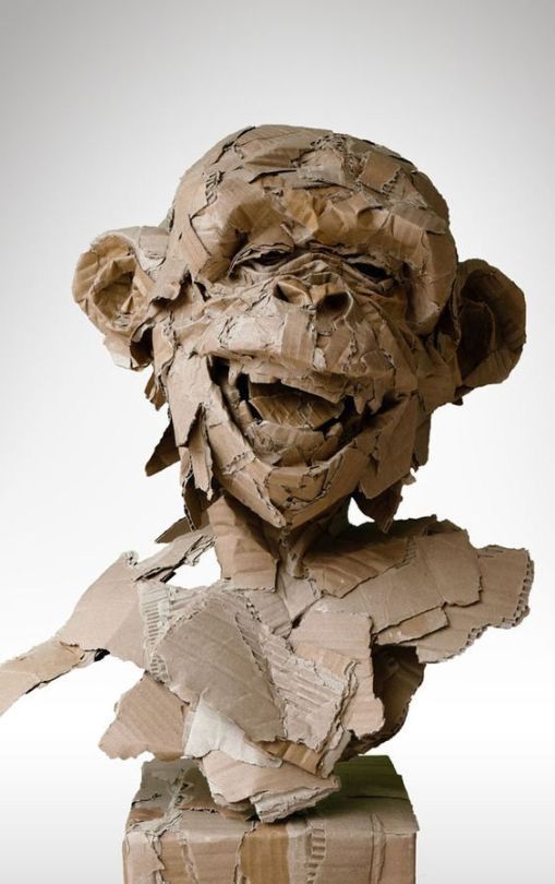 a sculpture made out of paper with a man's head sticking out of it