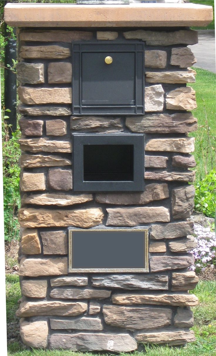 a stone fire place in the middle of some grass