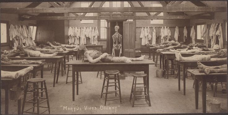 an old black and white photo of people in a room with beds on the floor