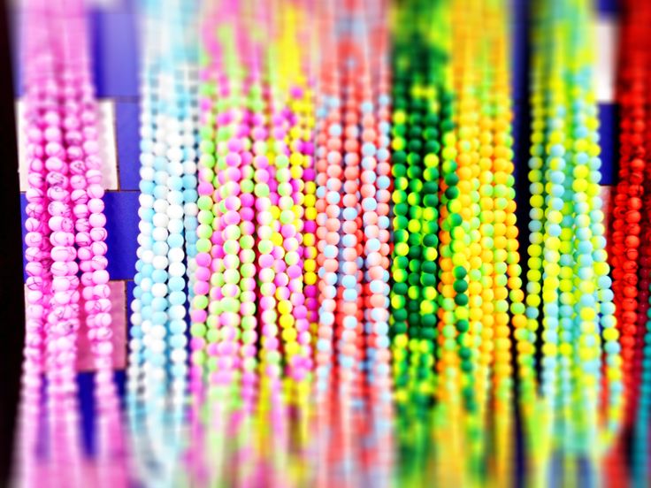 there are many different colored beads on the table