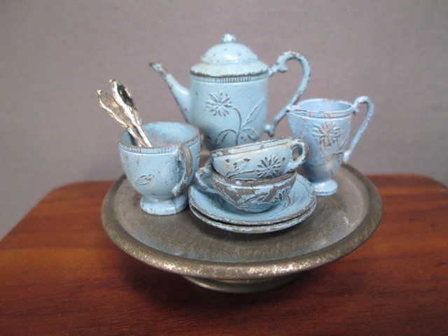 a tea set on a tray with cups and saucers