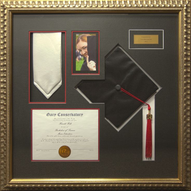 a graduation cap, diploma and other items are on display in a gold framed frame