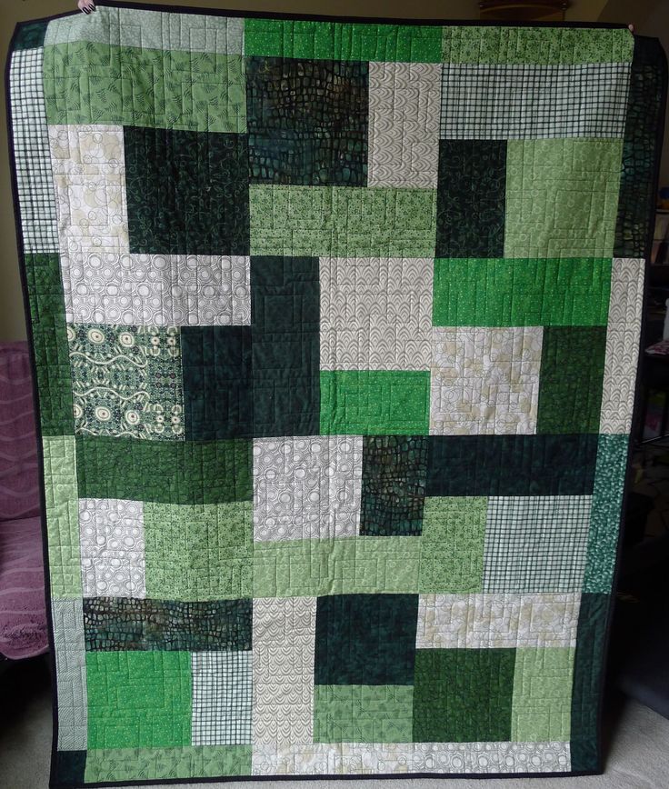 a green and white quilt with squares on it