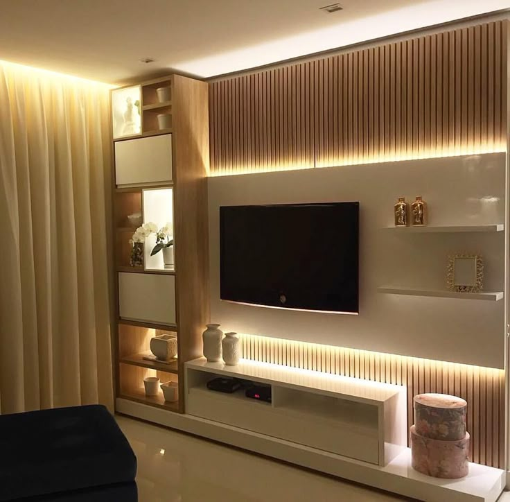 a modern living room with white walls and wooden paneling on the back wall, lighted by recessed lighting