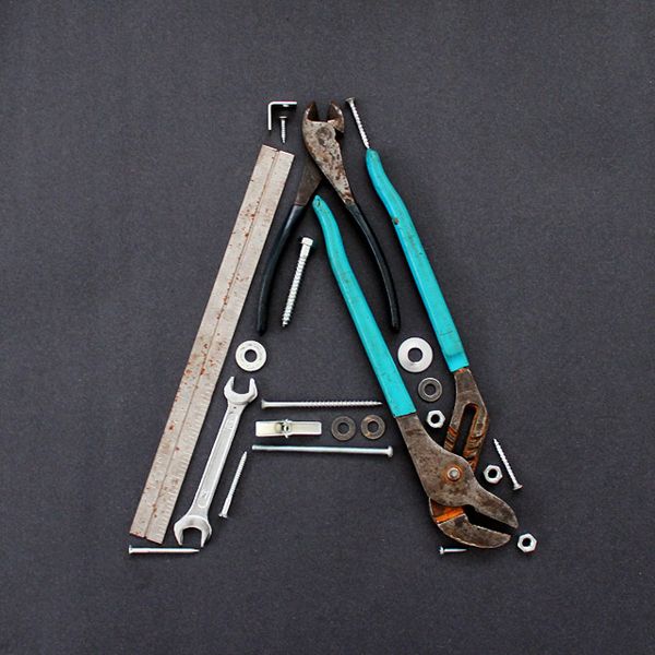 there is a pair of pliers and wrenches on top of the letter a