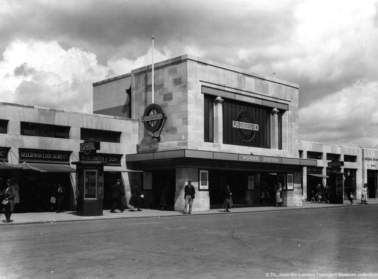 an old black and white photo of people walking in front of a building