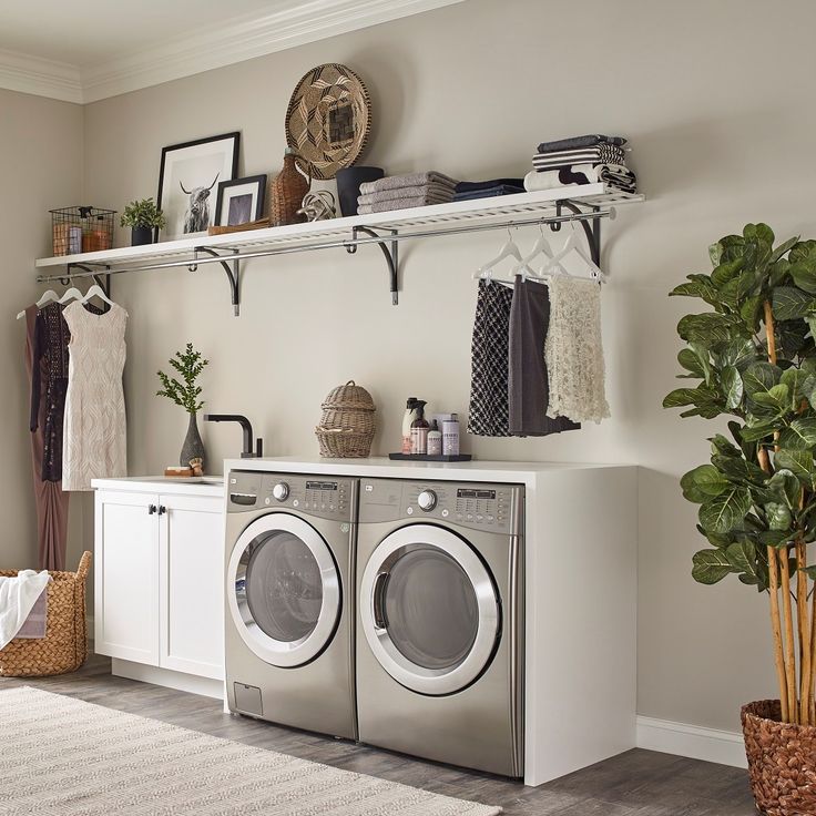 a washer and dryer in a room with shelves on the wall above them