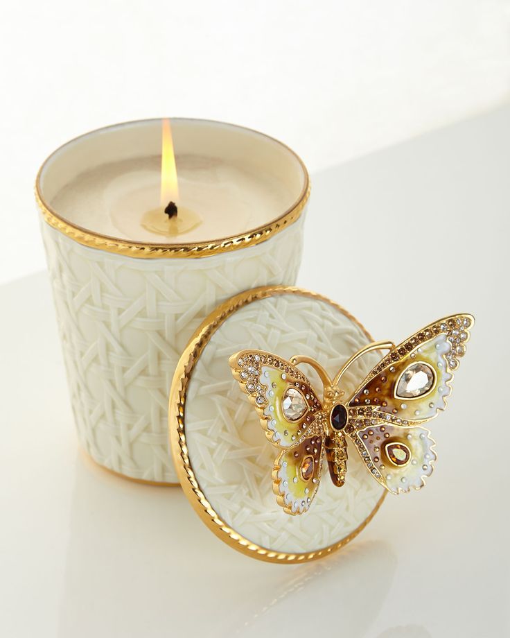 a white candle with a butterfly on it