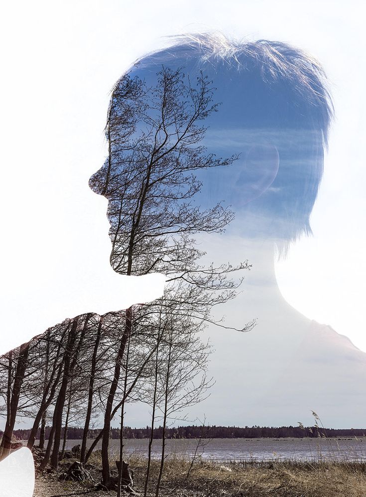 a man's face with trees in the foreground and water in the background