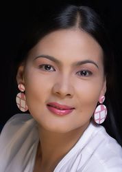 a woman in white shirt and pink earrings