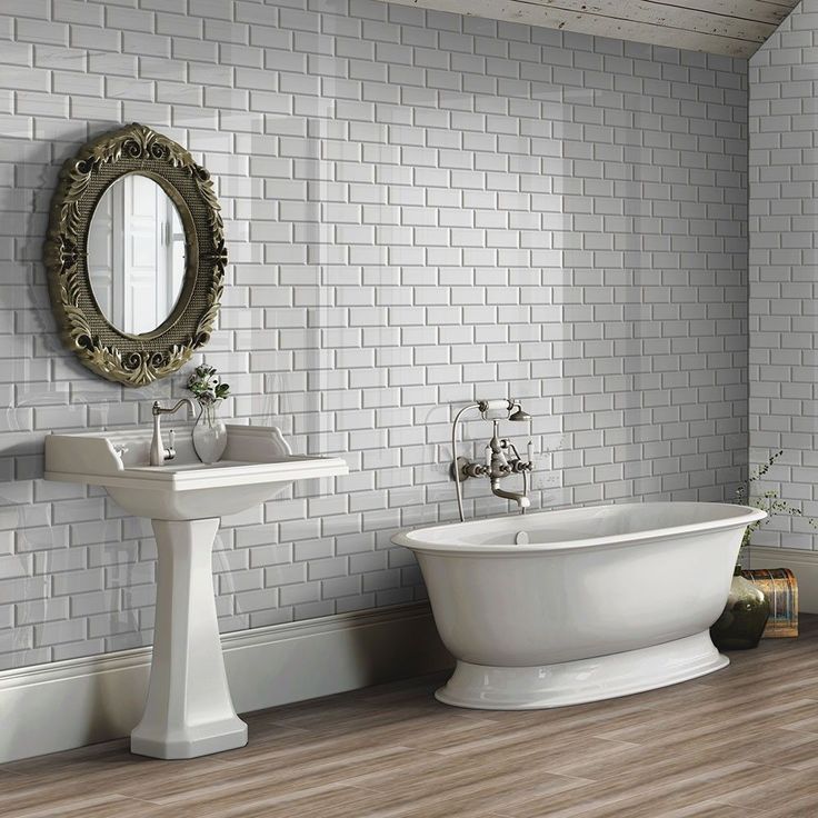 a bathroom with a tub, sink and mirror on the wall is shown in this image