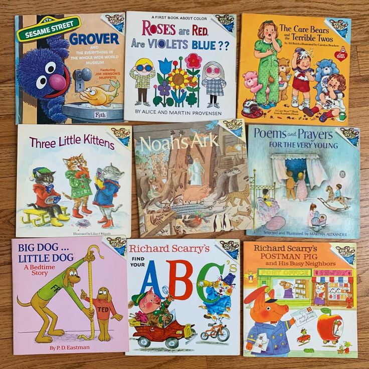 several children's books laid out on a wooden table with their names and pictures