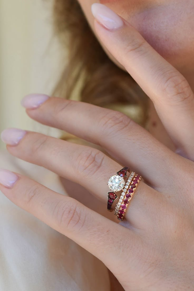 a woman's hand with a ring on it and a diamond in the middle