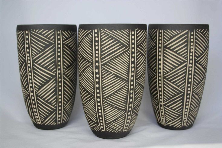 three black and white vases sitting next to each other