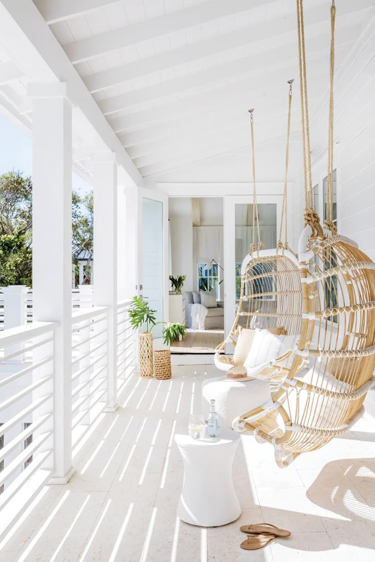 a woman walking down a porch next to a hammock hanging from the ceiling