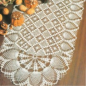 a white doily sitting on top of a wooden table next to nuts and flowers