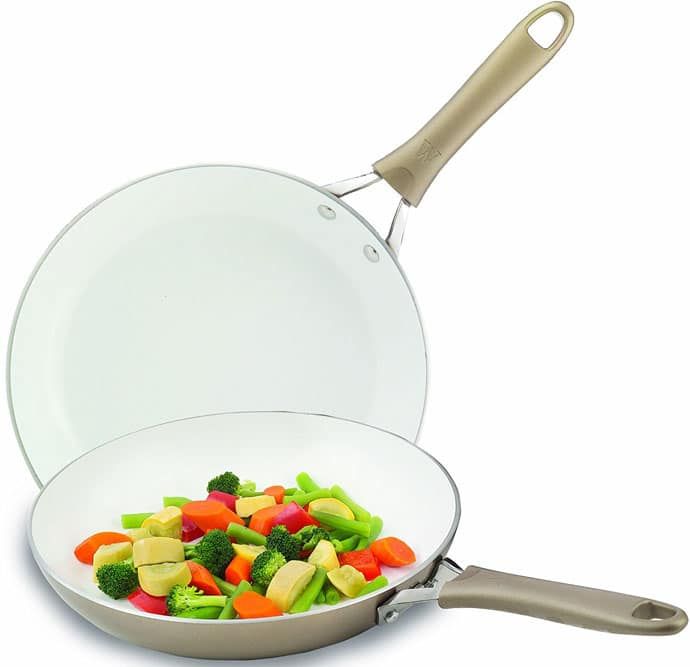 a frying pan filled with vegetables on top of a white counter