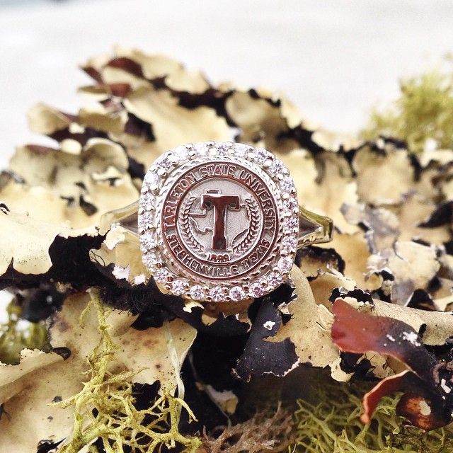 a ring with the letter t on it surrounded by leaves