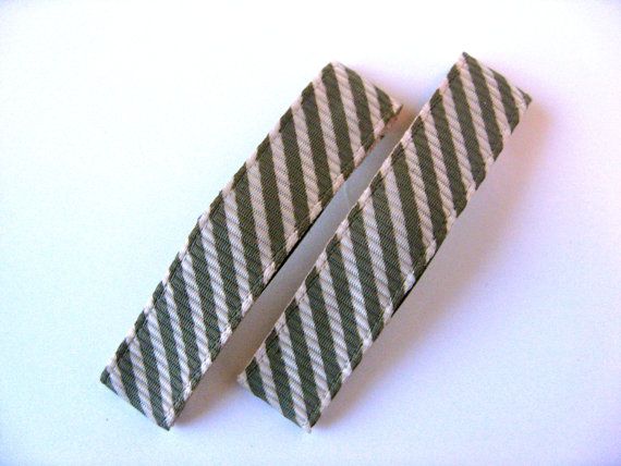 two pieces of gray and white striped paper next to each other on top of a table