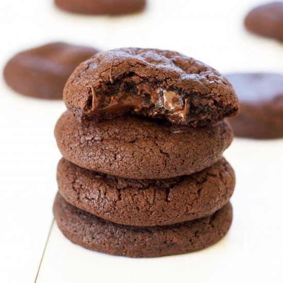 three chocolate cookies stacked on top of each other, with one cookie in the middle