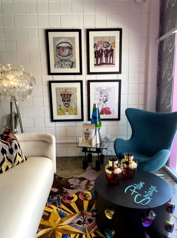 a living room filled with furniture and pictures on the wall next to a coffee table