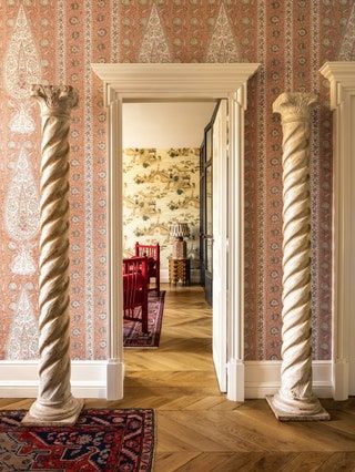 an ornate hallway with columns and rugs