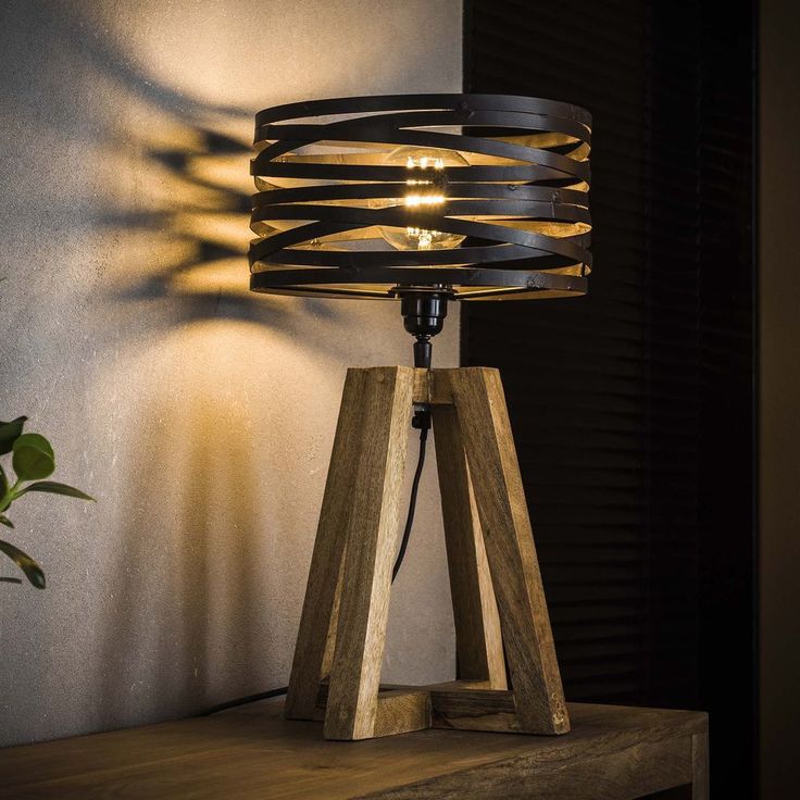 a wooden table lamp sitting on top of a shelf