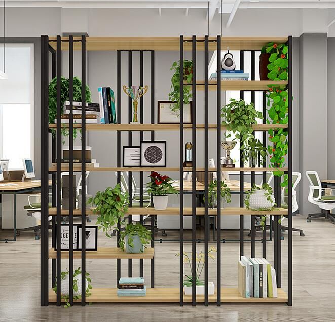 an office filled with lots of plants and bookshelves