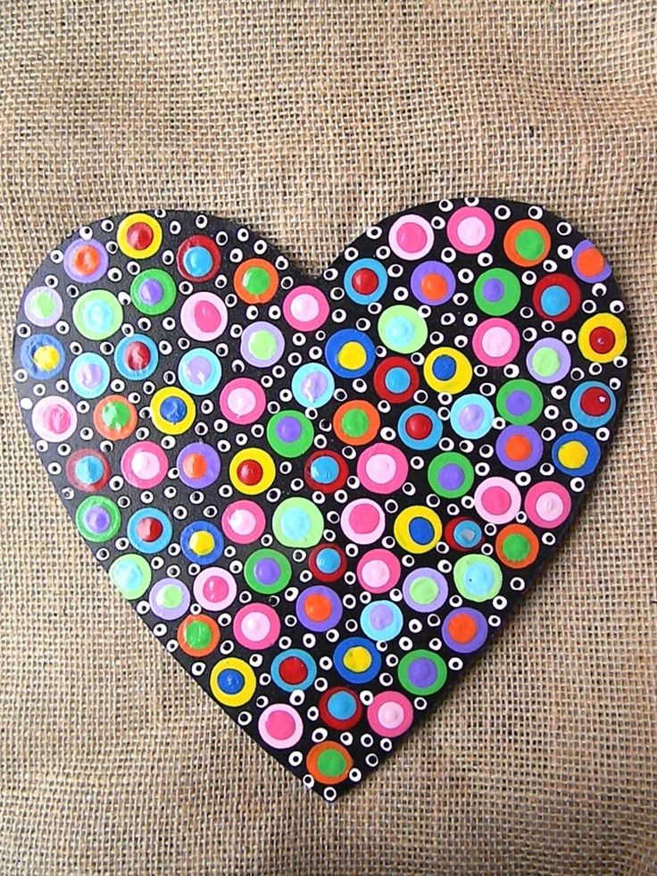 a heart shaped painting on the back of a couch with circles and dots painted on it