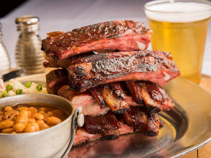 ribs, beans and beer on a silver plate with a glass of beer in the background